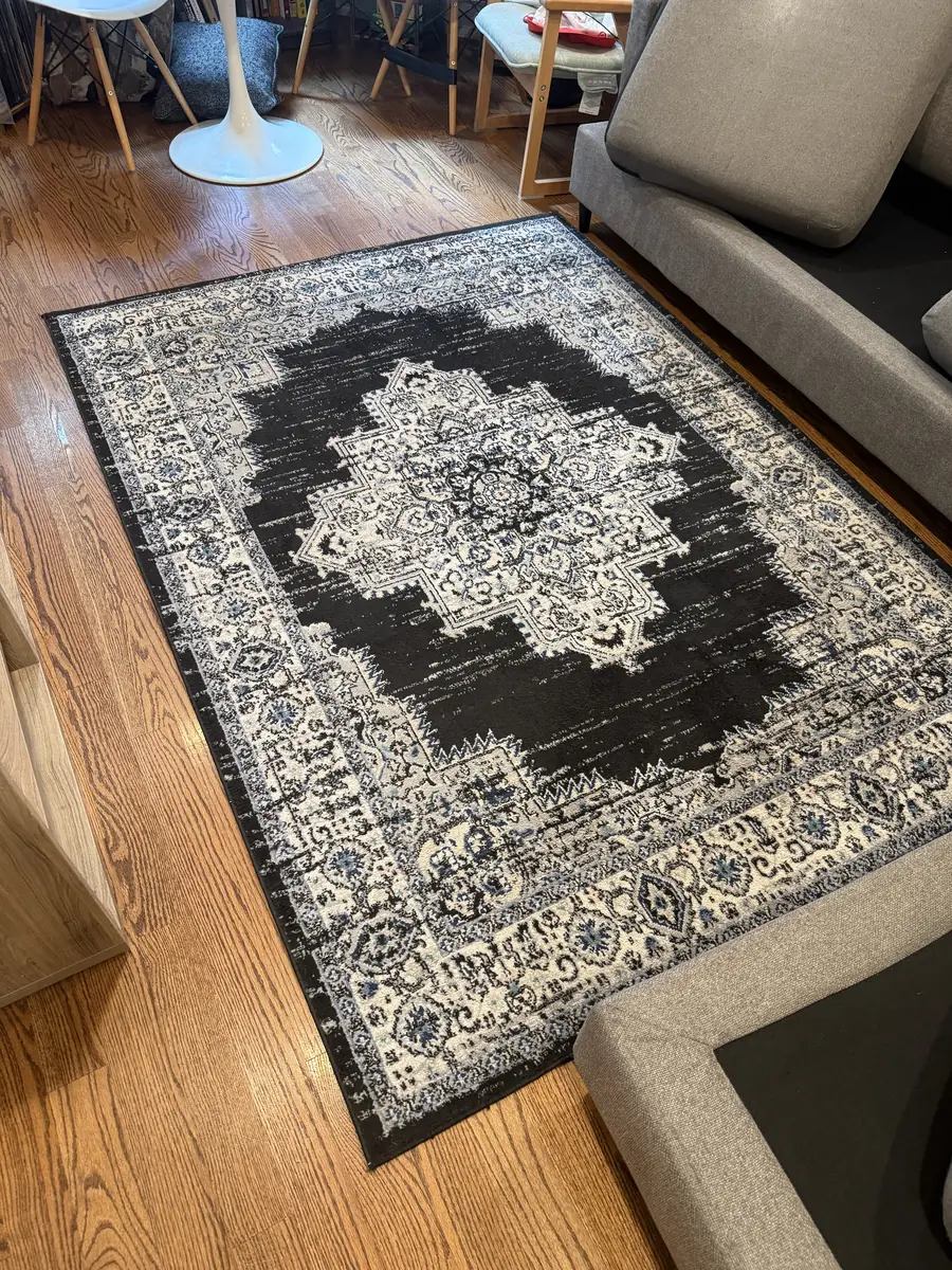 Black and white medallion area rug on a hardwood floor after professional on-site rug cleaning in Chicago