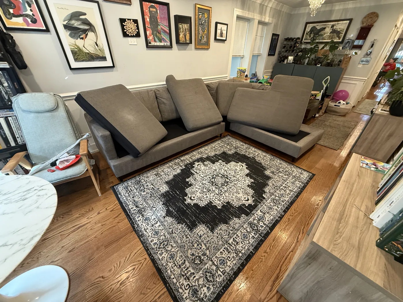 The same sectional sofa after cleaning, with cushions stood on edge to dry and the medallion area rug cleaned on-site
