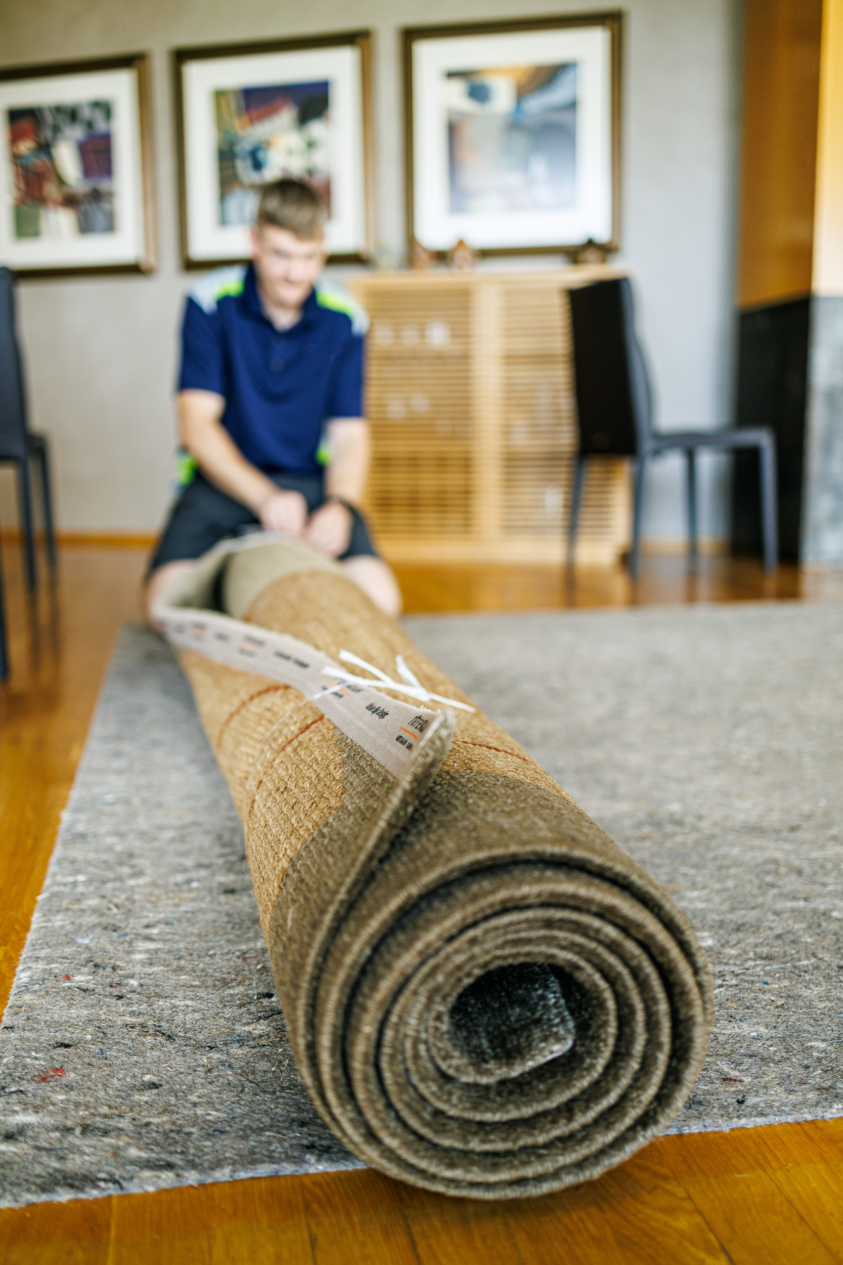 technician rolling up carpet for cleaning